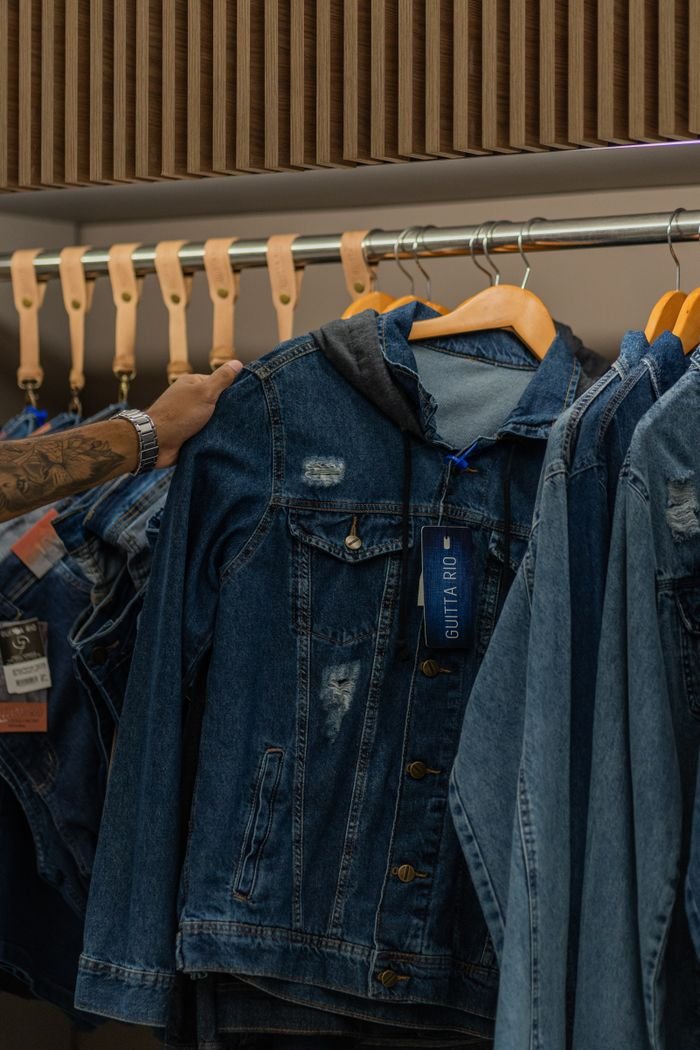 The Art of Drawing Readers In: Your attractive post title goes here Close-up of various denim jackets hanging on wooden hangers in a clothing store.