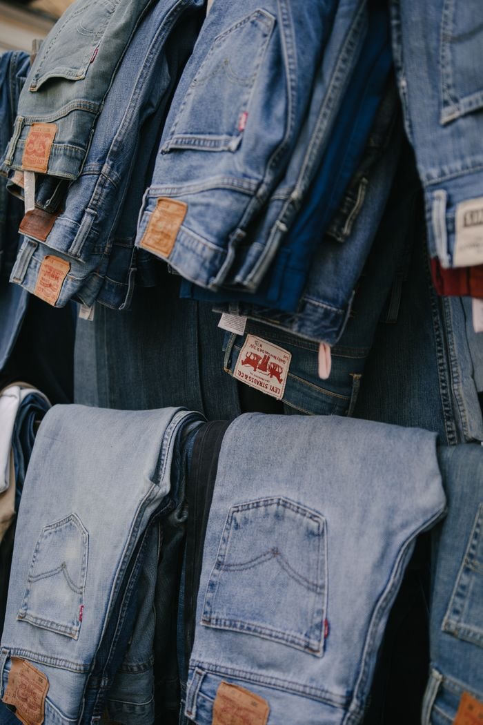 Crafting Captivating Headlines: Your awesome post title goes here Folded and hanging jeans in a clothing store in Madrid, showcasing fashion variety.